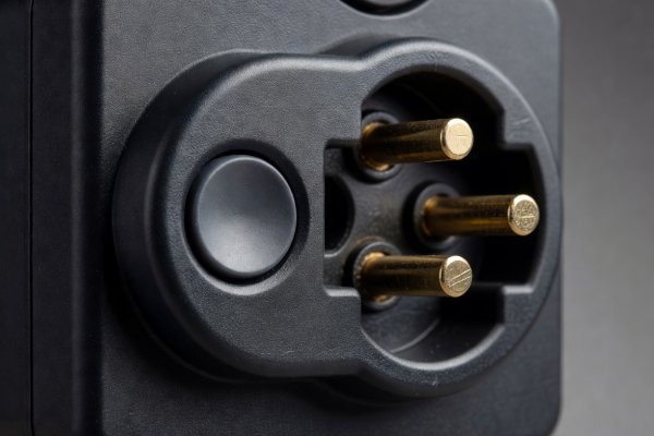Close-up view of a heavy-duty energy monitoring plug socket face and recessed physical button